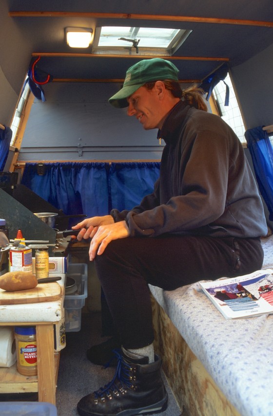 在皮卡車改裝的露營車內煮飯。